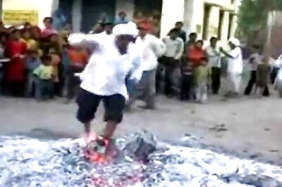 Hundreds gather to watch a priest walk through bonfire on Holi