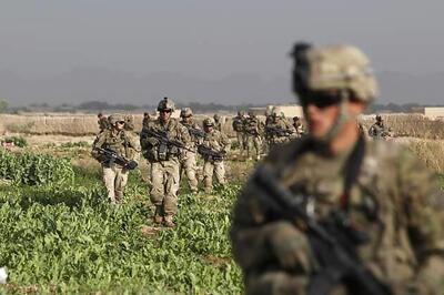 US troops pose with maimed Afghan insurgent bodies